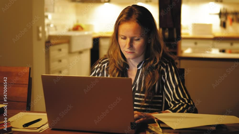 Stressful tired exhausted young woman working at night in the kitchen, having headache, touching her head. Overwhelmed student preparing for exams, study with computer laptop Stressful tired exhausted young woman working at night in the kitchen, having headache, touching her head. Overwhelmed student preparing for exams, study with computer laptop