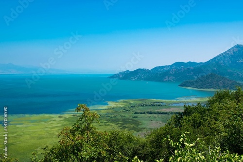 Scenic Viewpoint. Beautiful summer landscape of Skadar Lake with green and blue water, mountains hills. Montenegro.