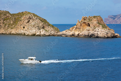 Islas Malgrats (Santa Ponsa, Mallorca, Islas Baleares). Barco con motor fueraborda navegando frente a las islas Malgrats y dejando una estela en el mar. photo