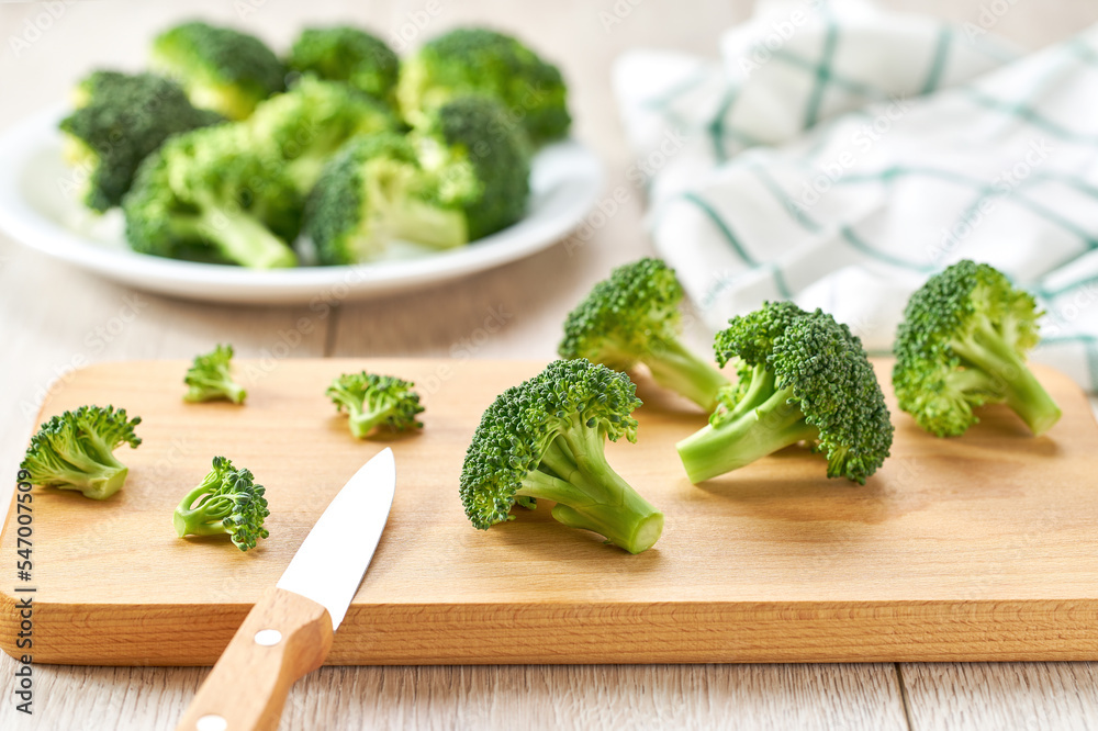 fresh broccoli florets on a wooden board , selective focus. fresh broccoli florets on a wooden board , selective focus.