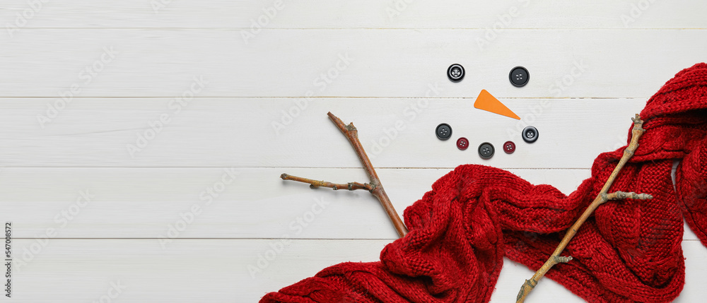Funny snowman made of scarf, buttons and tree branches on white wooden background with space for text Funny snowman made of scarf, buttons and tree branches on white wooden background with space for text