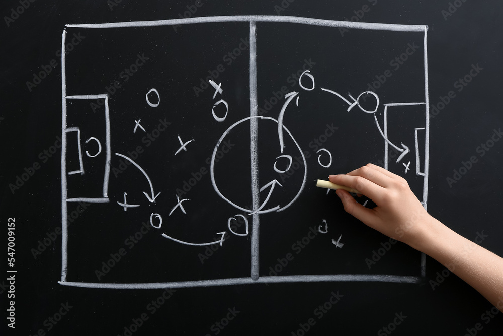 Woman drawing scheme of soccer game on blackboard Woman drawing scheme of soccer game on blackboard