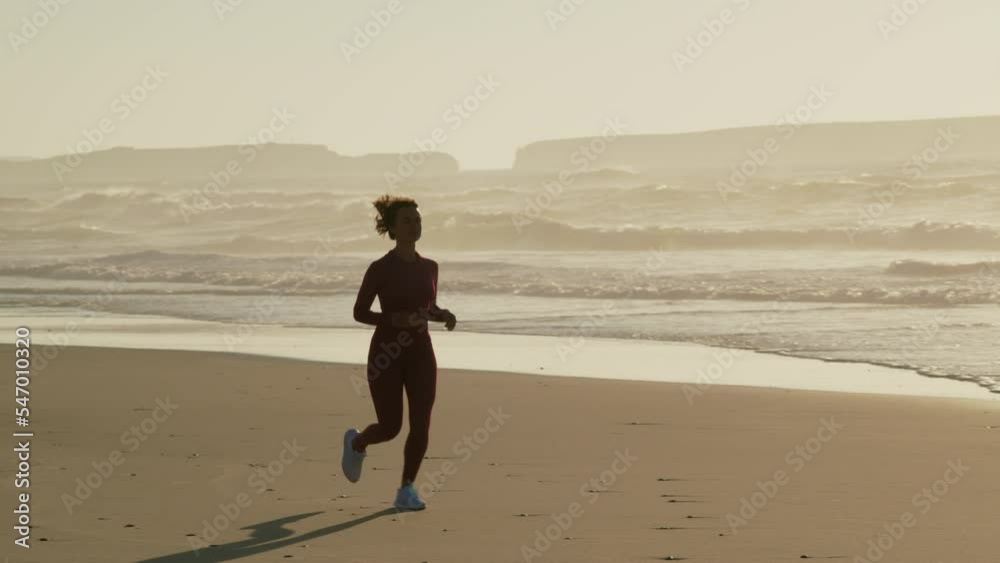 Woman jogging fast on sand, training, doing her cardio workout during summer vacation Woman jogging fast on sand, training, doing her cardio workout during summer vacation