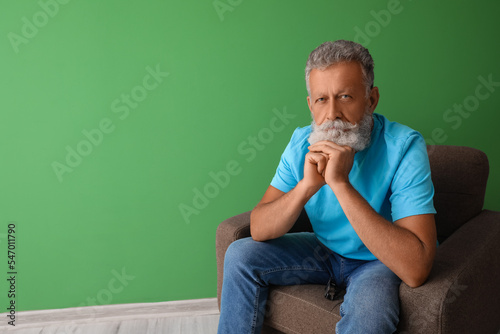 Thoughtful senior man sitti...