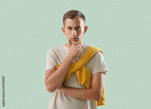 Thoughtful young man on gre...