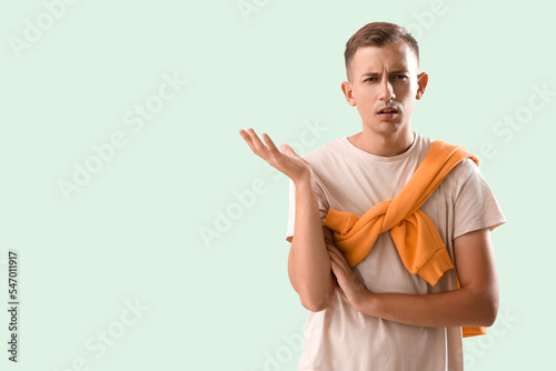 Confused young man on green...