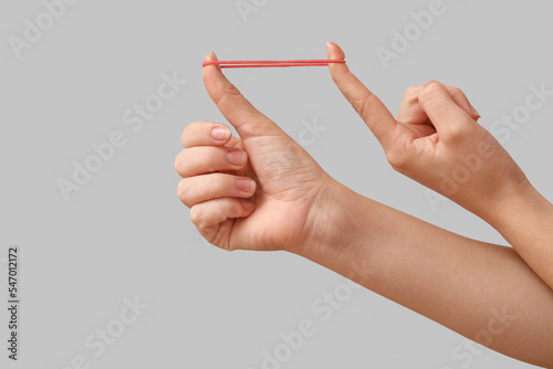 Woman with red rubber band on grey background photo