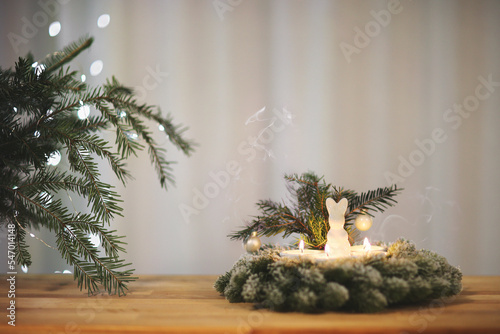 christmas new year wreath with rabbit figure lit candles green fir branch copy space soft focus