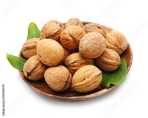 Plate of fresh walnuts on white background