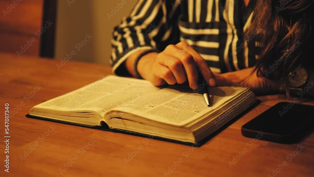 Woman Reading Scripture, Bible , God's word. Learning and reading a book. Young female reading, using a pen, reaing line by line. Christian faith. Jesus Christ 