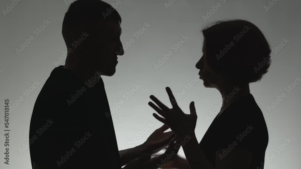 Family quarrel between husband and wife. Silhouette of a talking man and woman. The concept of conflict, dispute.