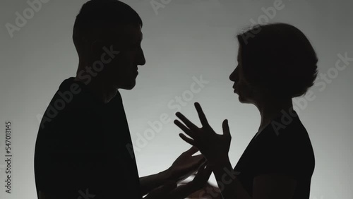 Family quarrel between husband and wife. Silhouette of a talking man and woman. The concept of conflict, dispute.