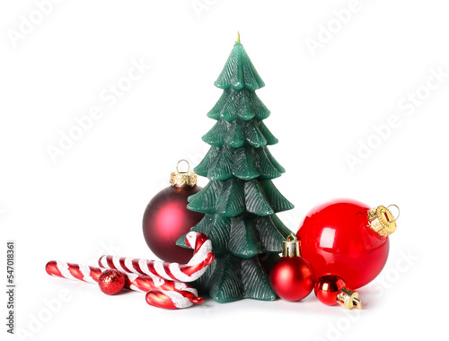 Christmas tree candle with balls and candy canes on white background