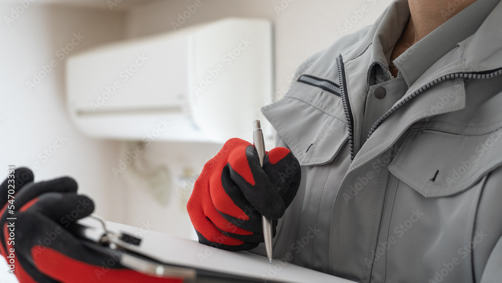 エアコンの掃除・点検をする作業服の男性｜見積イメージ