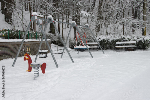 Empty playground and benches in park covered in snow during a winter day, Trivale Forest Park, Pitesti, Arges County, Romania