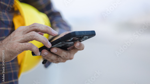 construction working touch screen smart phone at construction site photo