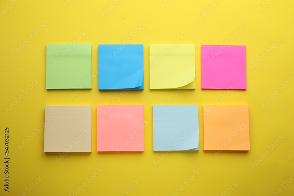 Paper notes on yellow background, flat lay Paper notes on yellow background, flat lay