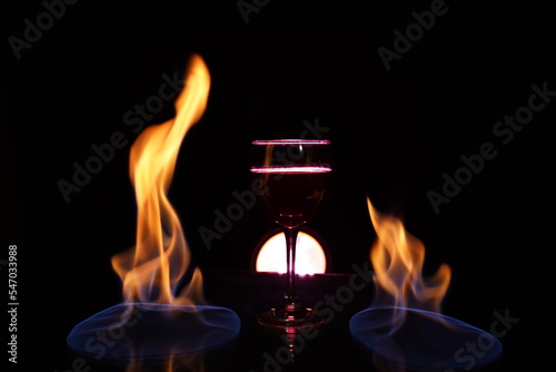 glass of red wine on the table with fire in the background fine art