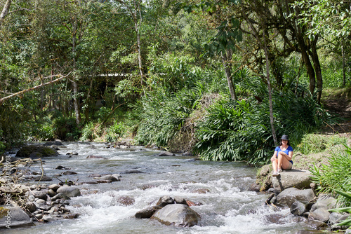 Latin woman sitting by the river