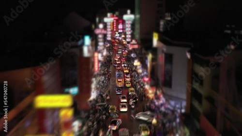 Aerial Hyperlapse over a traffic cars and a crowd of chinatown bangkok walking street at night. photo