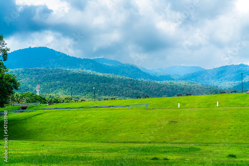 beautiful landscape green grass with in nature forest Mountain views spring with air atmosphere bright blue sky background abstract clear background texture with white clouds.