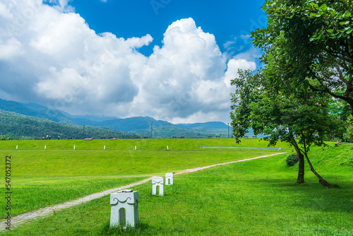 A public place leisure travel wide lawn and big tree landscape at Park to relax with in nature forest Mountain views spring cloudy sky background with white cloud in Chiang Mai University.