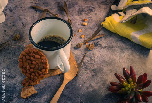 Cups of coffee and fried nuts are placed on the table.