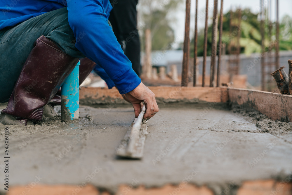 onstruction worker leveling concrete floor with trowel. onstruction worker leveling concrete floor with trowel.