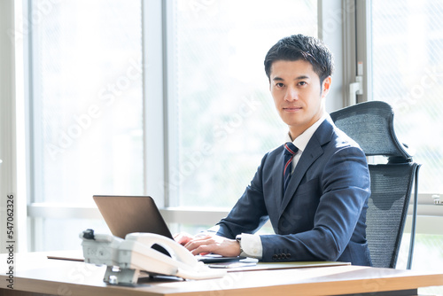 パソコン作業をするスーツを着た日本人男性