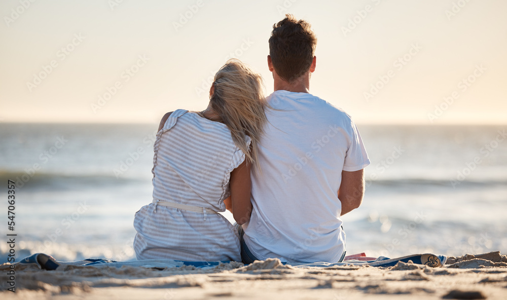 Fototapeta premium Beach, love and couple relaxing on the sand while watching the ocean waves together on vacation. Travel, romantic and man and woman on seaside holiday to bond, relax and rest by the sea in Australia.