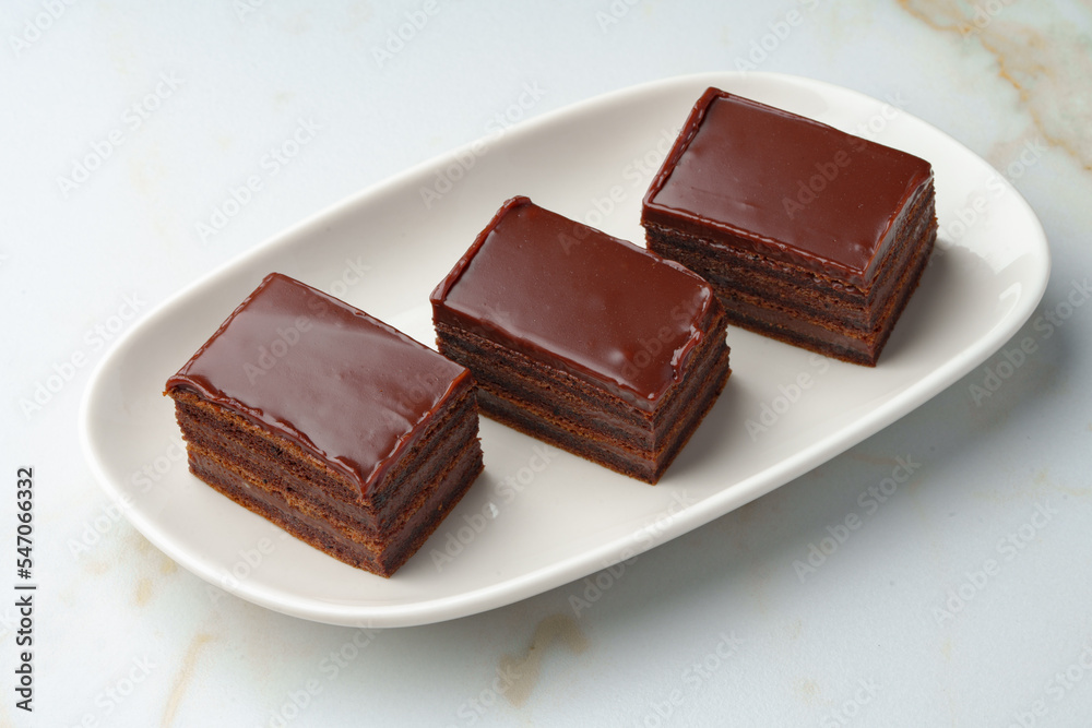 Three piece of chocolate brownie cake on white plate