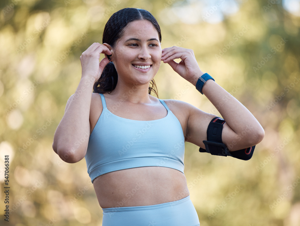 Woman, fitness and music with an athlete wearing earphones for motivation songs before a exercise workout in nature. Working out, running and athletic female streaming a podcast on her phone outside Woman, fitness and music with an athlete wearing earphones for motivation songs before a exercise workout in nature. Working out, running and athletic female streaming a podcast on her phone outside