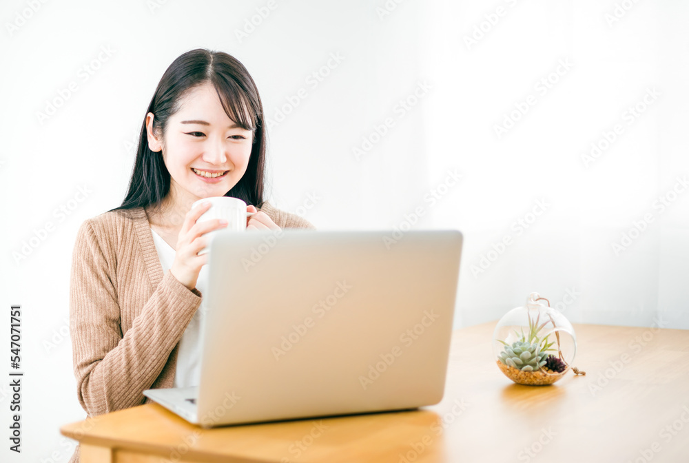 家でノートパソコンを使ってテレワークやネットショッピングする日本人女性
家でノートパソコンを使ってテレワークやネットショッピングする日本人女性