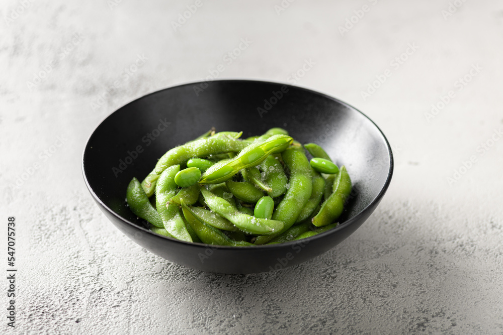 steamed edamame, soybeans on a gray concrete background, selective focus