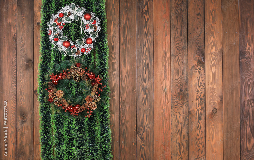 christmas wreath with green tinsel on wooden wall