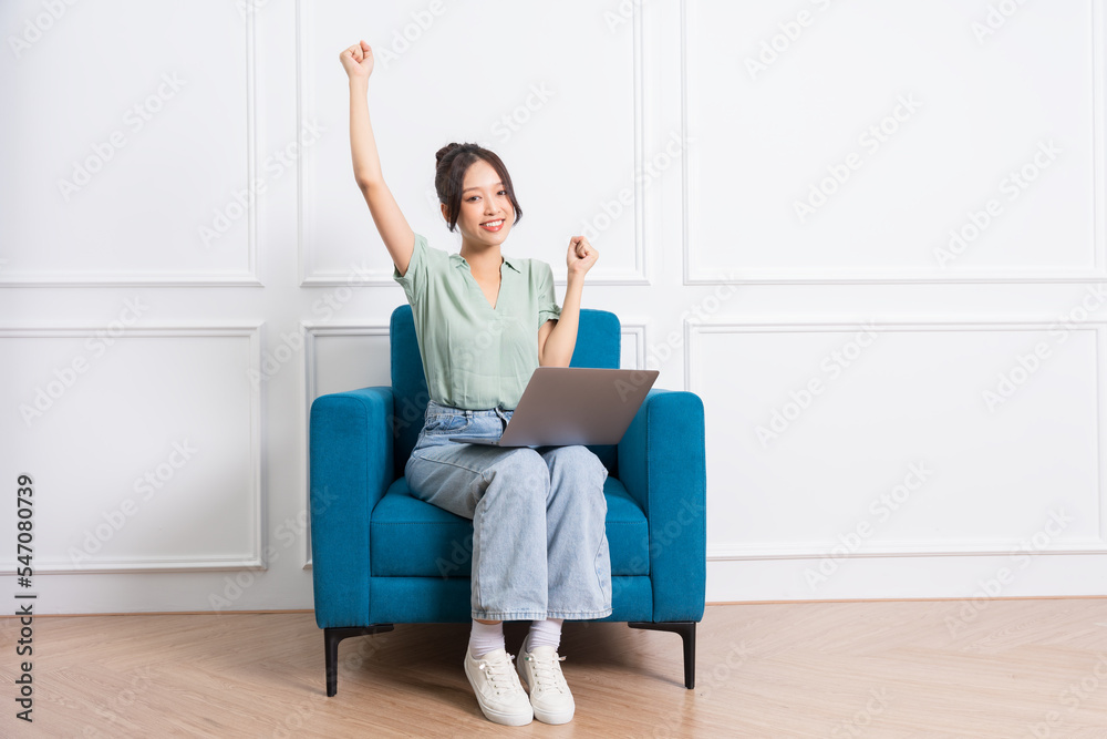 image of young Asian girl sitting on sofa at home image of young Asian girl sitting on sofa at home