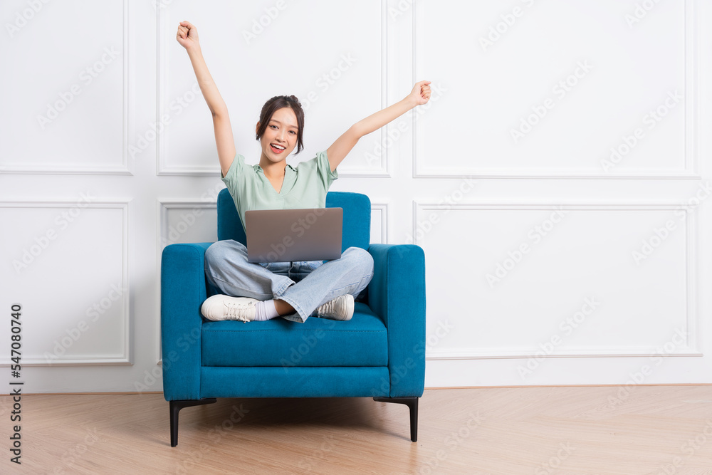 image of young Asian girl sitting on sofa at home image of young Asian girl sitting on sofa at home
