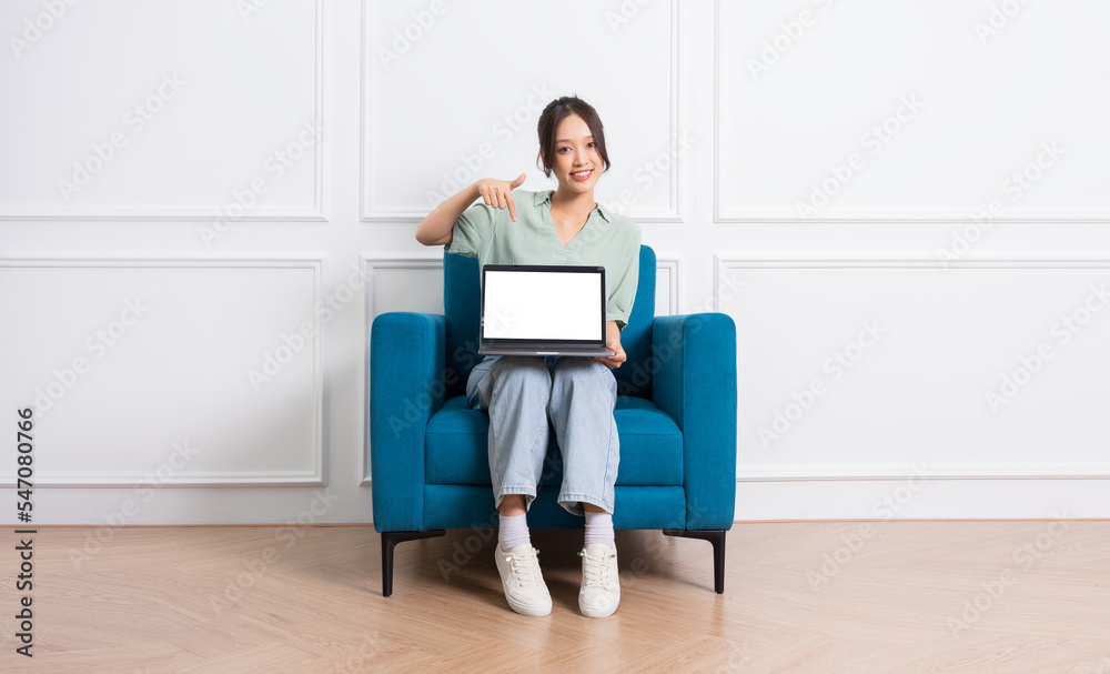 image of young Asian girl sitting on sofa at home image of young Asian girl sitting on sofa at home
