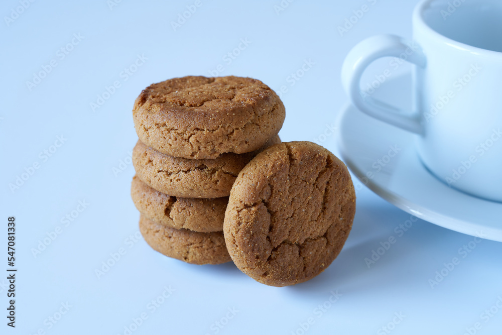 Crispy cookies with a white cup and saucer on a white background. The concept is breakfast. Crispy cookies with a white cup and saucer on a white background. The concept is breakfast.