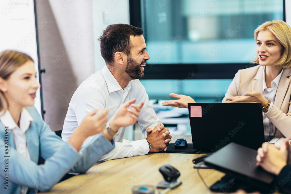 Office colleagues having discussion during meeting in conference room. Group of men and women in conference room. Office colleagues having discussion during meeting in conference room. Group of men and women in conference room.
