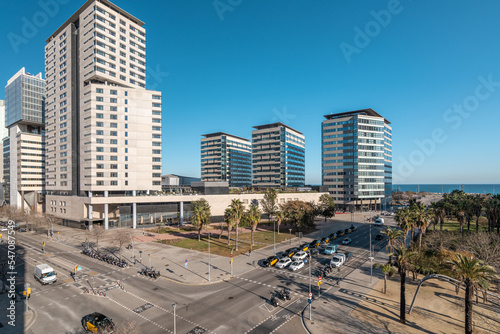 Modern buildings and car traffic intersection in the coastal residential area of Diagonal Mar in Barcelona, Spain