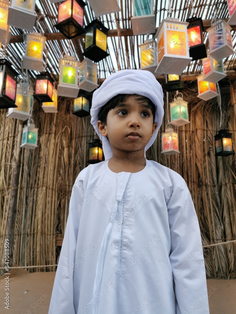 Smiling happy Middle Eastern young boy wearing a traditional Emirati ...