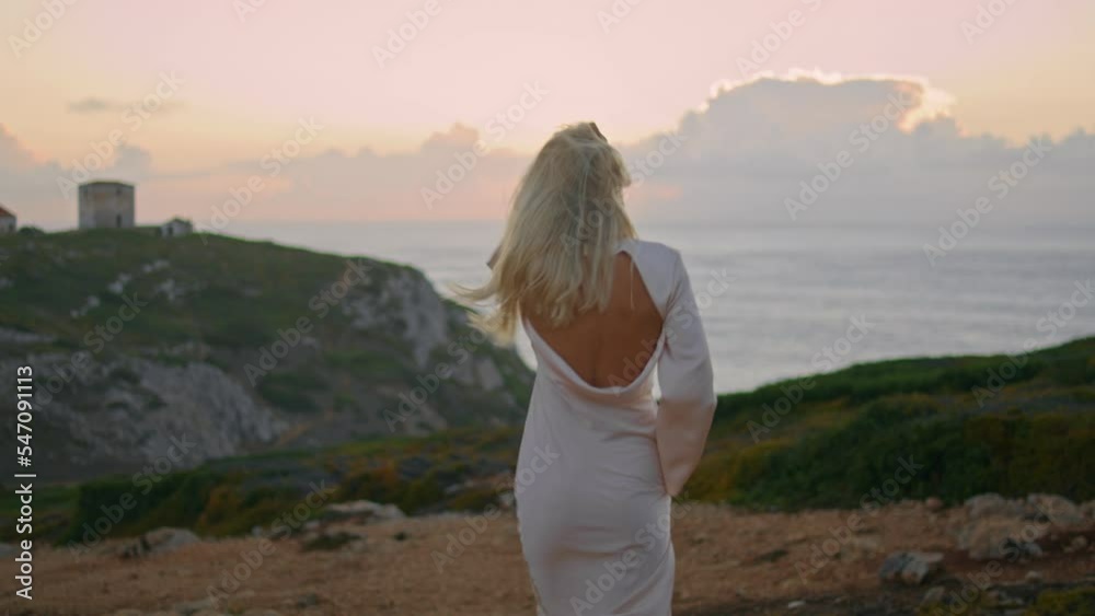 Blonde woman moving castle seashore back view. Happy girl running empty valley Blonde woman moving castle seashore back view. Happy girl running empty valley