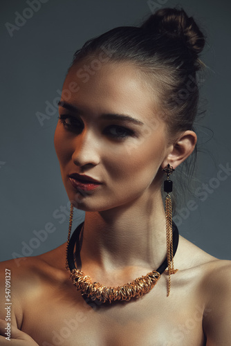 Low key photo of young woman with necklace
