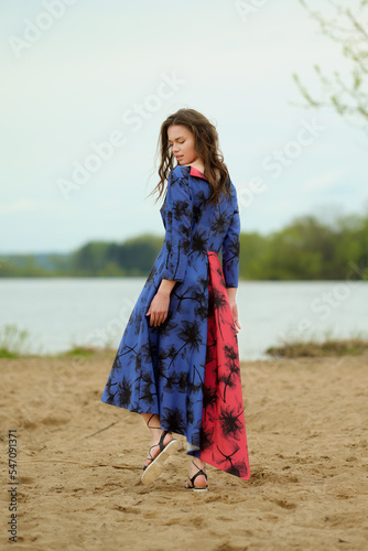 Cute young woman walking on the sand
