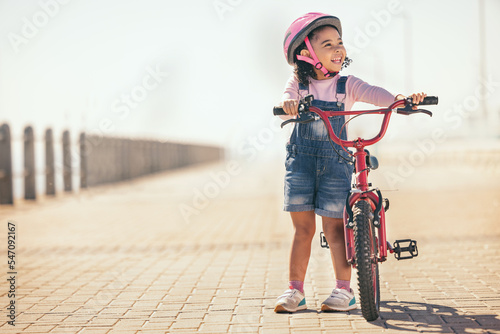 Fototapeta Naklejka Na Ścianę i Meble -  Fun, thinking and girl cycling with a bike in the city for sustainability, carbon footprint and eco friendly transport. Happy, smile and child with an idea and a bicycle in the street for happiness