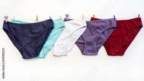 A set of panties hang on a rope. A set of colorful, cotton classic panties. Close-up. Underwear. Woman pants.