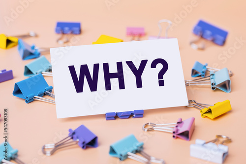 The Word Why message on card for presentation, business. Business card and many colourful paper clips on beige background. Business concept. Home Office