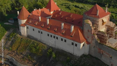 Bauska Castle under reconstruction, aerial drone circling around at golden hour photo