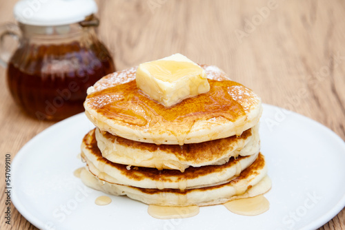 Stack of freshly made buttermilk pancakes with maple syrup and butter 